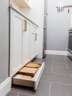 an open drawer in the middle of a kitchen floor