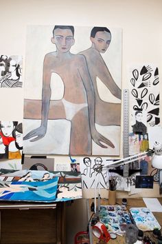 an artist's studio with paintings on the wall