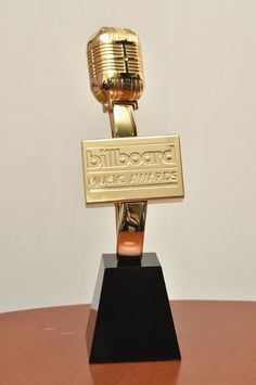 a gold trophy sitting on top of a wooden table