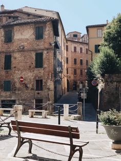 there is a bench in the middle of an alley way with buildings on both sides