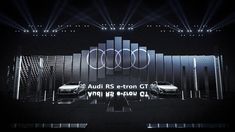 two audi cars on stage with lights behind them