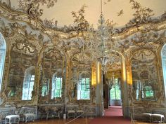 an ornately decorated room with mirrors and chairs