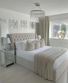 a bedroom with a large bed and chandelier