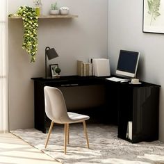 a computer desk with a laptop on top of it next to a chair and shelf