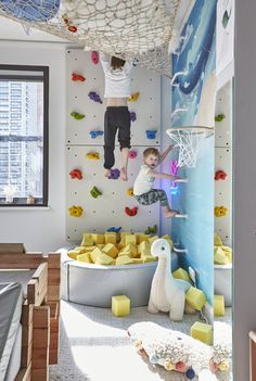 a child is climbing on a wall in a room with toys and other items around