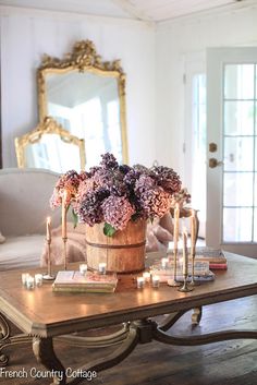 a coffee table with candles and flowers on it