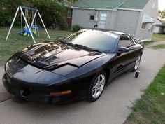 a black sports car parked in front of a house