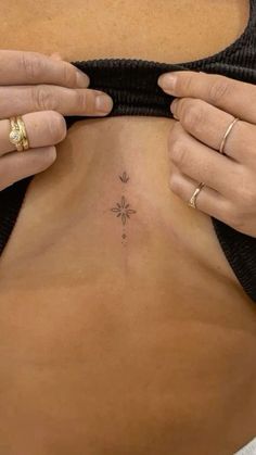 a woman is showing off her tiny tattoo on her stomach and the bottom part of her body