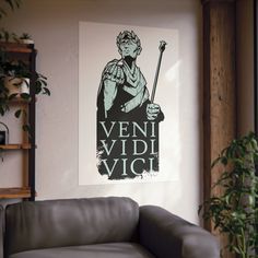 a living room with a couch and a poster on the wall that says veni vidi vici