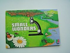 a small book with an image of a microscope and flowers on the cover that says small wonders