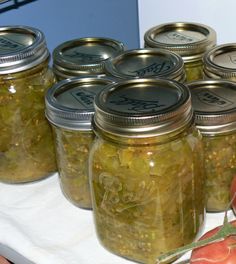 several jars filled with pickles sitting on top of a table