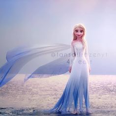 a woman in a white and blue dress standing on the beach with her wings outstretched