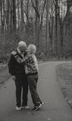 an older couple embracing on a path in the woods