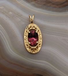 "CJ8380PT On Hold Maine Pink tourmaline 14k yellow gold necklace. This pendant is set with Maine pink tourmaline from the Dunton Quarry in Newry, Maine. The stone is .80ct, 7x5mm. Dainty filigree design surrounds the gemstone. Pendant measures approximately 19mmx9mm. This piece is sold on an 18\" 14k yellow gold box style chain. This piece can be special ordered in 14k white gold." Elegant Oval Tourmaline Pendant, Vintage Sapphire Ring, 14k Yellow Gold Necklace, Amethyst And Diamond Ring, Filigree Design, White Gold Earrings, Yellow Gold Pendants, 14k White Gold Ring, Lovely Earrings