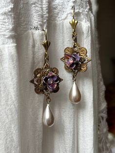 For this set, I assembled together purple lavender shade metal flowers salvaged from antique broken clip on earrings.  I set them in a flower metal bead cap itself glued to a vintage and sturdy highly detailed brass stamping. I added light purple pinkish tiny vintage rhinestones in each of the flower as the original ones were gone. I salvaged 2 large pearlized glass beads from another set of antique earrings and attached them at the bottom.  To complete the look, I used the beautiful and classic Purple Vintage Aesthetic, Manga Jewelry, Purple Beaded Earrings, Lavender Jewelry, Ethereal Jewelry, Romantic Jewelry, Metal Bead, Antiques Jewelry, Purple Earrings