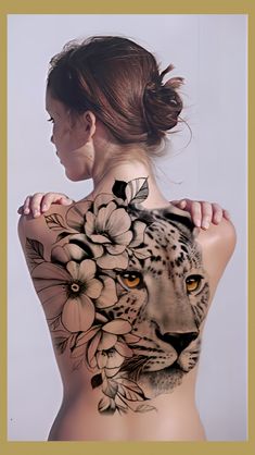 a woman with a tattoo on her back has a tiger and flowers painted on it