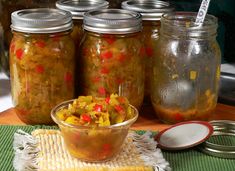 several jars filled with food sitting on top of a table next to a bowl and spoon