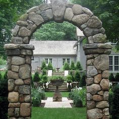 a stone arch in the middle of a yard