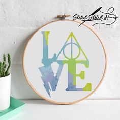 a cross stitch pattern with the words love and harry potter on it, next to a potted plant