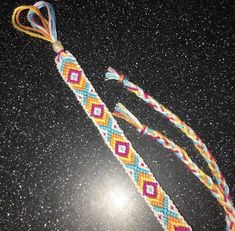 two colorful bracelets on top of a black table