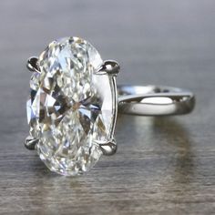 an oval cut diamond sits on top of a wooden table