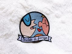 a patch with an image of two people kissing each other on top of a white blanket