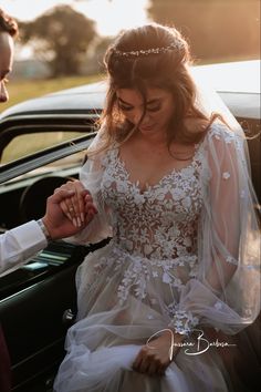 a bride and groom are getting out of their car at the wedding ceremony, holding hands