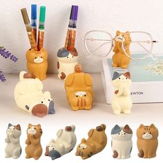 the cat figurines are on display next to pens and pencils