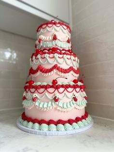 a three tiered cake with red, white and green icing on it's sides