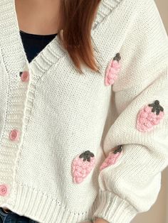 a close up of a person wearing a sweater with pink flowers on the front and back