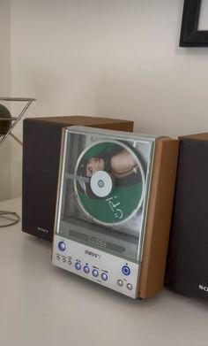 two stereos sitting next to each other on top of a white table with a cd player