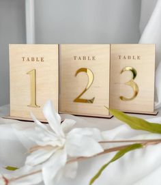 three wooden table numbers are shown on a bed