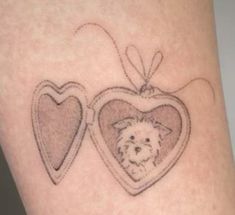 a small dog in a heart shaped frame tattoo on the leg with two hearts attached to it