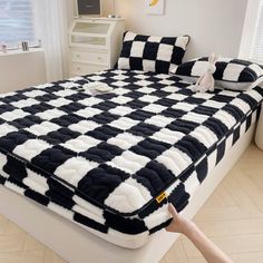 a bed with black and white checkered sheets