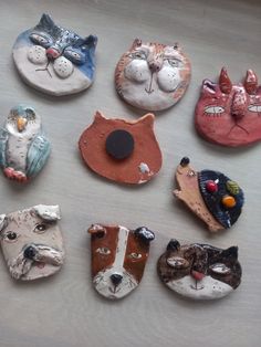 there are many different animal heads on the table together, including one cat and two dogs