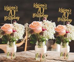 three mason jars filled with pink roses and baby's breath on top of a wooden table