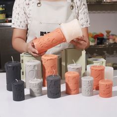 a woman is making candles out of clay