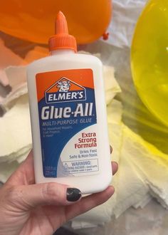 a person holding a bottle of glue in their hand