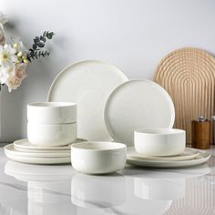 white dishes and cups are arranged on a table