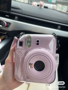 a person holding a pink camera in their hand