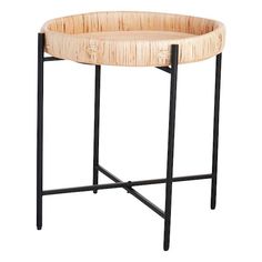 a round table with black metal legs and a bamboo tray on it's side