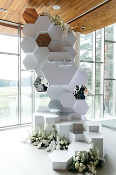 an artistic display in the middle of a room with lots of flowers and hexagonal shapes