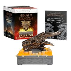 the game of thrones and dragon are on display in front of two boxed books