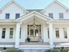 a white house with two front porches and an entry way leading to the first floor