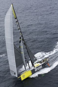 a yellow and black sail boat in the water