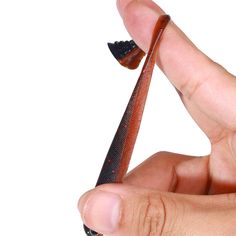 a person is holding a small piece of material in their hand, which looks like a fish