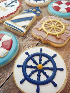 decorated cookies are arranged on a table with ships wheel, life preserver and more