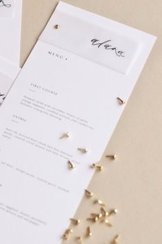 the wedding stationery is laid out on top of each other with gold studs