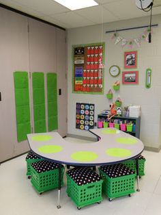 a classroom with green and white polka dots on the table, several storage bins