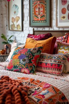 a bed topped with lots of colorful pillows next to a painting on the wall behind it